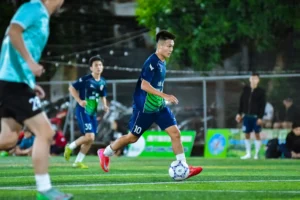 Dynamic action shot of a football player in full motion during a match in Hà Nội, Vietnam.