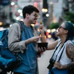 A couple enjoying street food in a lively city scene, capturing moments of joy and adventure.