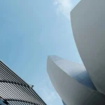 Dynamic view of sleek architectural designs reaching into a clear blue sky.