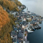 An aerial shot of Hallstatt, Austria surrounded by autumn foliage and lake views.