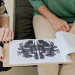 A close-up of a Rorschach inkblot test during a psychotherapy session, highlighting mental health care.