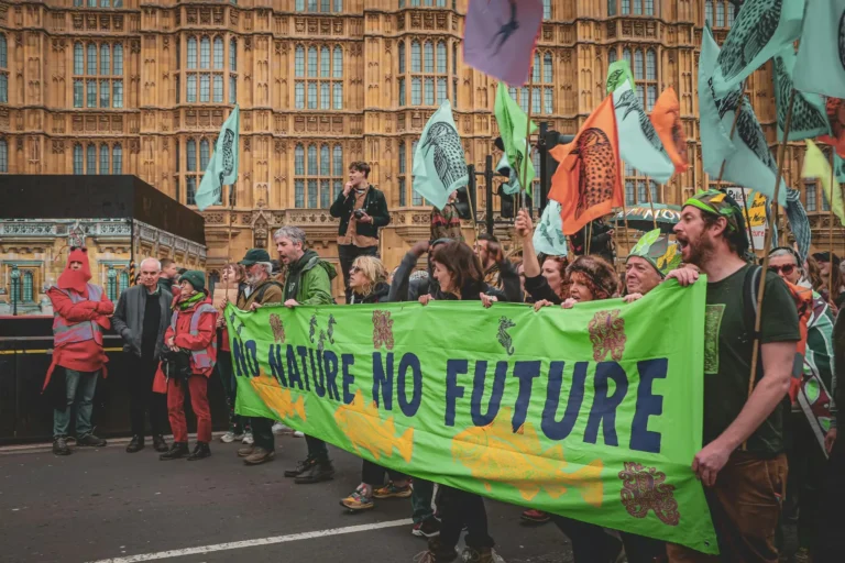 Protesters in London hold a banner advocating for environmental conservation. City streets echo with calls for action.