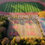 Aerial photograph of a football and tennis court in Nanjing, China during autumn.